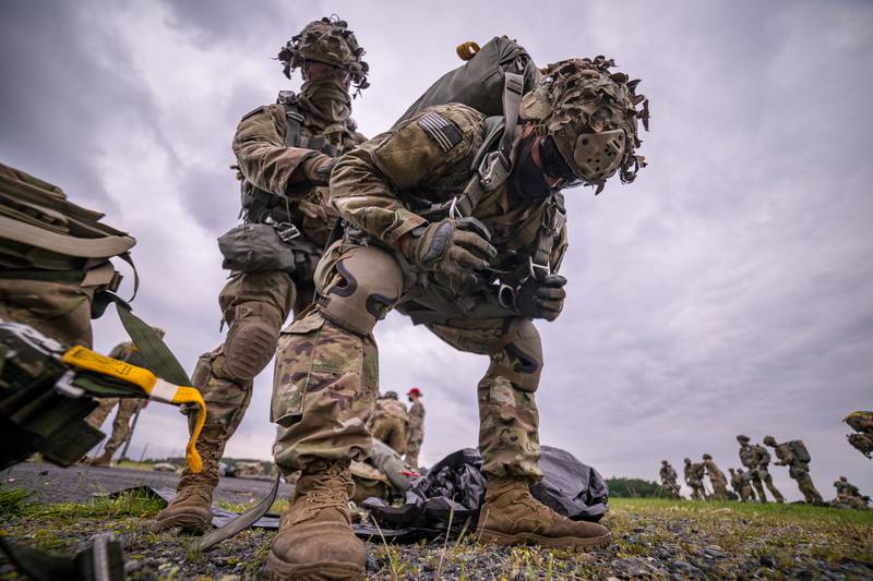U.S. Army paratroopers from the 1st Squadron (Airborne), 91st Cavalry Regiment, 173rd Airborne Brigade, help each other don parachutes in preparation for an airborne jump at Grafenwoehr Army Air Field, Germany, June 10, 2020.