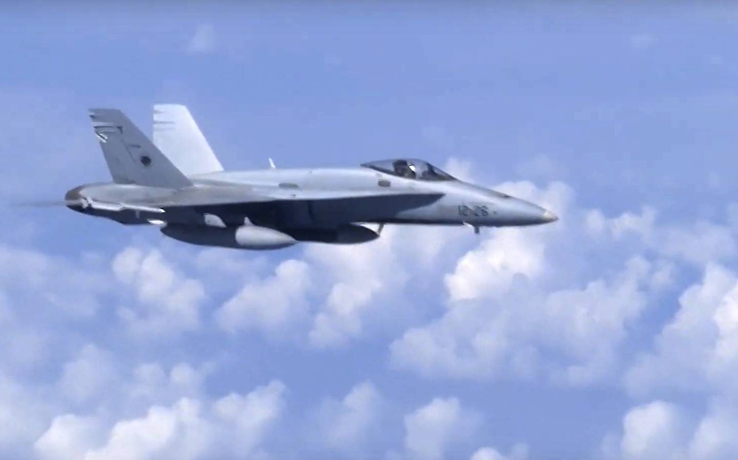 In this video grab taken from a footage on Aug. 13, 2019, and distributed by Russian Defense Ministry Press Service, a NATO F-18 warplane is viewed from the window of a passenger plane carrying Russian Defense Minister Sergei Shoigu over the Baltic See.