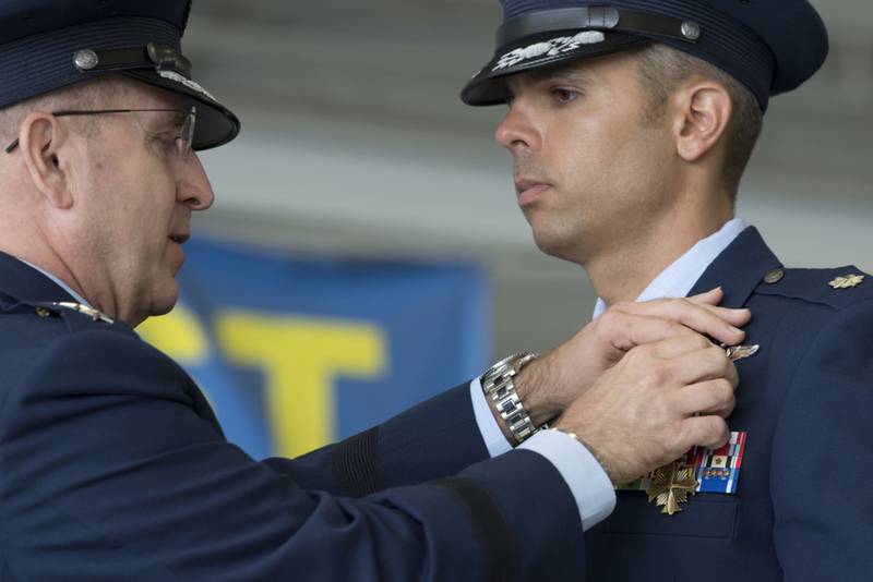 U.S. Air Force Lt. Col. Christopher McCall, 73rd Expeditionary Special Operations Squadron Shadow 71 aircraft commander, receives the Distinguished Flying Cross from U.S. Air Force Lt. Gen. Jim Slife, commander of Air Force Special Operations Command, during a ceremony at Hurlburt Field, Florida, June 22, 2021. Shadow 71 was an AC-130J Ghostrider flight that directly supported American and Afghan forces during an ambush and subsequent firefight, repeatedly engaging multiple enemy positions while simultaneously coordinating a multitude of other support functions in the air. (Tech. Sgt. Victor Caputo/Air Force)