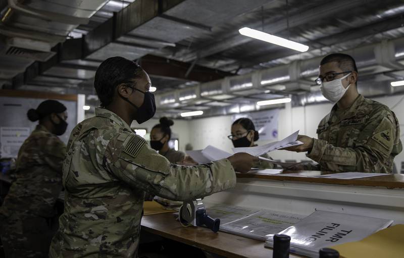 Army 2nd Lt.  Daii Gardner and Spc.  Natasha Washington distributes ballots to soldiers at the Theater Gateway, Camp Arifjan, Kuwait on October 21, 2020.
