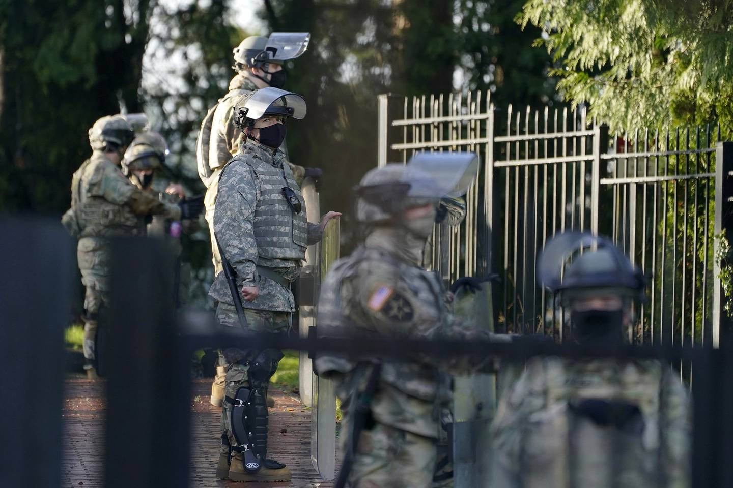 Members of the Washington National Guard stand along a perimeter fence at the Governor's Mansion, Sunday, Jan. 10, 2021, at the Capitol in Olympia, Wash.
