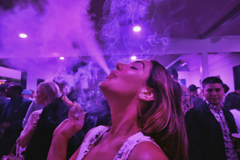 A guest takes a puff from a marijuana cigarette at the Sensi Magazine party celebrating the 4/20 holiday in the Bel Air section of Los Angeles on April 20, 2019. (Richard Vogel/AP)