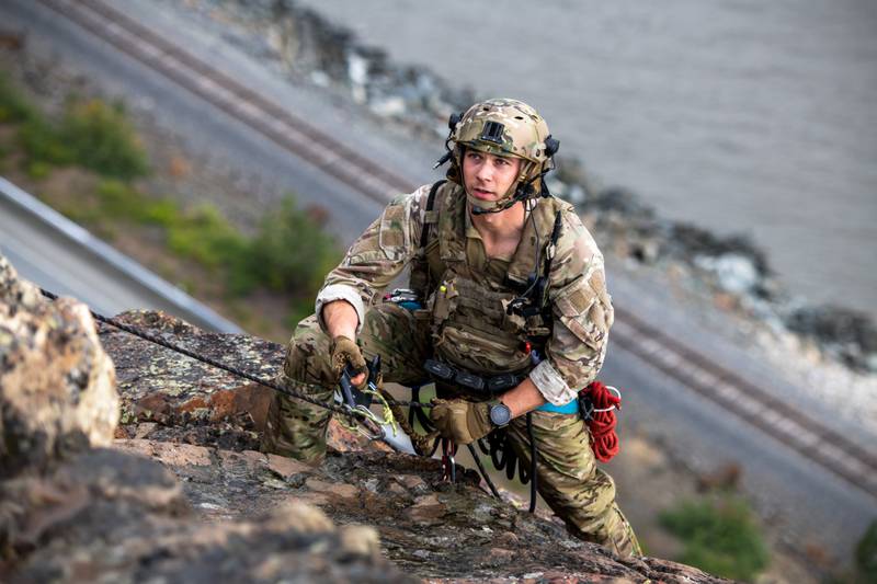 Staff Sgt. Trenten Collins, a tactical air control party specialist assigned to Detachment 1, 3rd Air Support Operations Squadron, approaches the cliff top during mountaineer training at Sunshine Ridge, Alaska, July 22, 2022. (Senior Airman Patrick Sullivan/ Air Force)