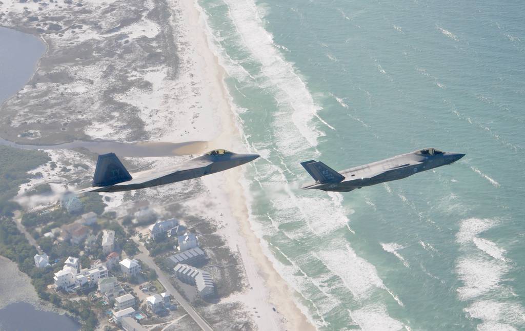 A F-22 Raptor from the 325th Fighter Wing flies alongside a F-35 Lightning II from the 33rd Fighter Wing over the Emerald Coast. Tyndall Air Force Base, Fla., will receive three F-35 squadrons starting in 2023. (Air Force/1st Lt. Savanah Bray)