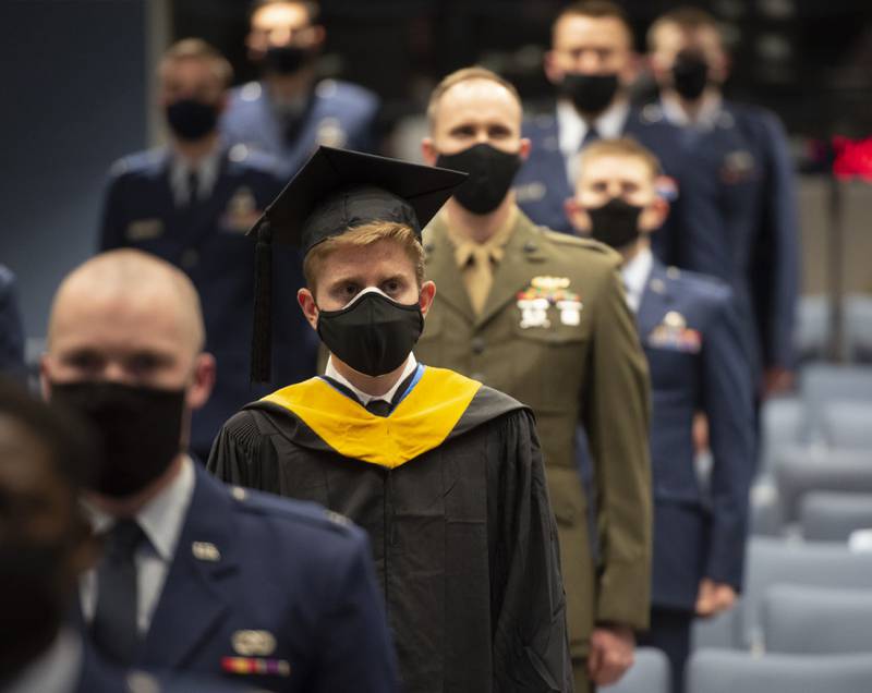 Nathan R. Boone and his classmates take their seats at the start of the Air Force Institute of Technology graduation ceremony March 25, 2021, at Wright-Patterson Air Force Base, Ohio. Approximately 250 advanced degrees were awarded to airmen and Space Force guardians. (R.J. Oriez/Air Force)