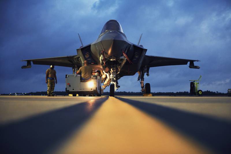 U.S. Air Force weapons load crew members load an AIM-120 advanced medium-range air-to-air missile on an F-35 Lightning II during Exercise Combat Archer at Eglin Air Force Base, Fla., June 10, 2020