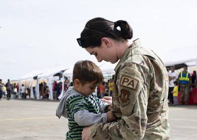 U.S. Air Force Capt. Shelby Chapman, 86th Airlift Wing Public Affairs Mission Partner Support chief, comforts a child at Ramstein Air Base, Germany, Sept. 7, 2021. Chapman leads the community engagement team for Operation Allies Refuge. (Staff Sgt. Jourdan Barrons/Air Force)