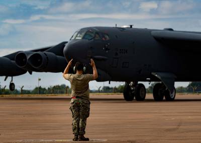 A 23rd Aircraft Maintenance Unit crew chief from Minot Air Force Base, North Dakota, guides a 23rd Expeditionary Bomb Squadron B-52H Stratofortress to its parking apron at RAF Fairford, United Kingdom, Aug. 18, 2022. (Senior Airman Michael A. Richmond/Air Force)