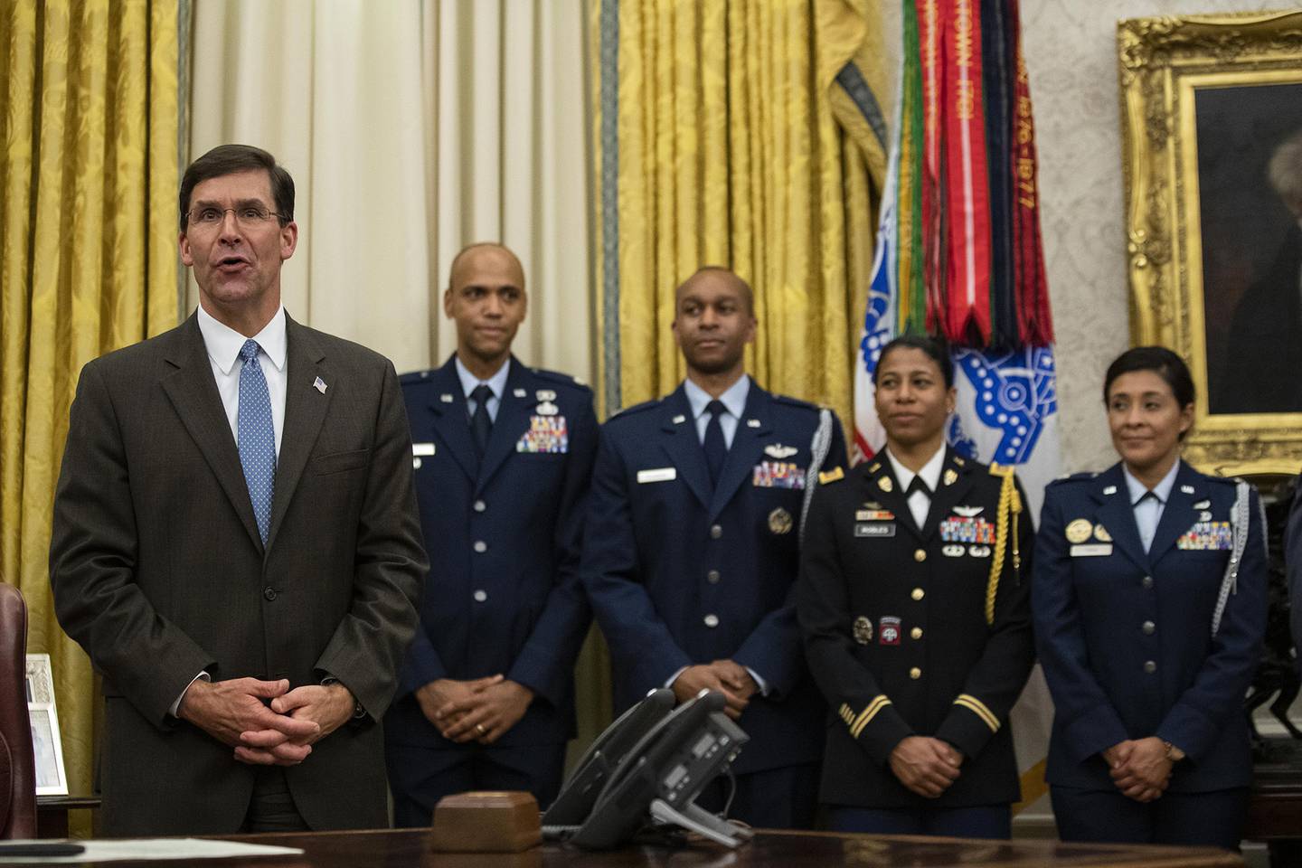 Secretary of Defense Mark Esper, left, speaks after a ceremony to swear in Gen. Charles Q. Brown Jr. as chief of staff of the Air Force in the Oval Office of the White House, Tuesday, Aug. 4, 2020, in Washington.