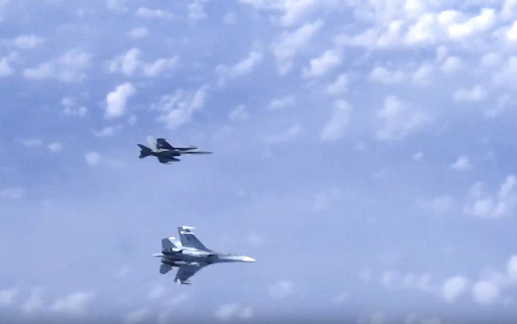 In this video grab taken from a footage on Aug. 13, 2019, and distributed by Russian Defense Ministry Press Service, a Russian air force's Su-27 fighter jet, bottom, maneuvers to ward off a NATO F-18 warplane over the Baltic Sea.