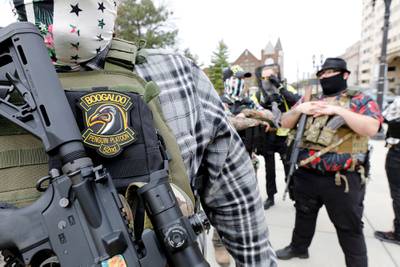 A group tied to the Boogaloo Bois holds a rally as they carry firearms at the Michigan State Capitol in Lansing, Mich., on Oct. 17, 2020.