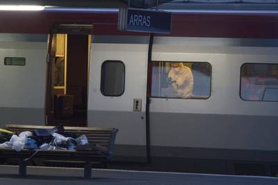 In this Aug. 21, 2015, file photo, a police officer videos the crime scene inside a Thalys train at Arras train station, northern France, after a gunman opened fire with an automatic weapon.