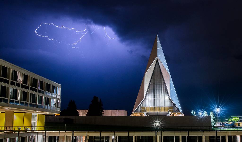 A late evening thunderstorm on Aug. 2, 2019, lights up the sky above the Cadet Chapel at the U.S. Air Force Academy, Colo.