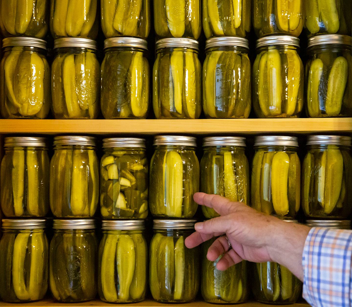 Boyd Elliott shows off his pickles he has stacked in a cabinet in his home in Louisa County on Thursday, Oct. 13, 2022 in Fredericksburg, Va.