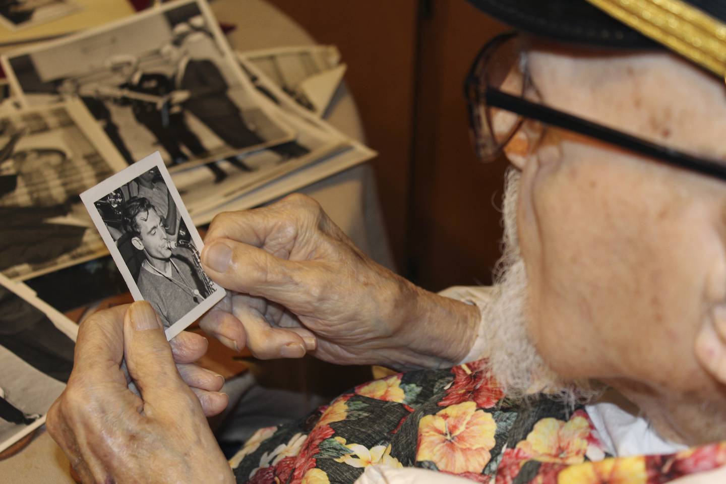Pearl Harbor survivor Ira "Ike" Schab, 103, looks at an old photo of himself with a saxophone while sitting at the kitchen table in his home in Beaverton, Ore. on Monday, Nov. 20, 2023.