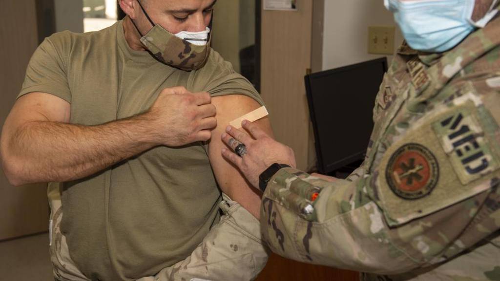 Tech. Sgt. Thabit Jubran, a security forces specialist in the 163d Security Forces Squadron, receives his second dose of the COVID-19 vaccine from Master Sgt. Joshua Liko, superintendent of aerospace medicine at the 163d Attack Wing at March Air Reserve Base, California, Dec. 5, 2021. (Senior Airman Neil Mabini/Air National Guard)
