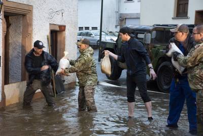 Members from the 52nd Civil Engineer Squadron from Spangdahlem Air Base, Germany, work with German first responders and community members to lay sandbags in the town of Binsfeld, Germany, July 14, 2021. The 52 CES was able to fill and deliver around 1,800 sandbags to help protect homes and businesses in the communities of Binsfeld and Neiderkail after heavy rainfall caused severe flooding in the region. (Tech. Sgt. Warren Spearman/Air Force photo)