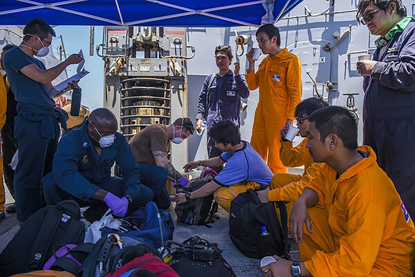 In this June 13, 2019, photo released by the U.S. Navy, sailors aboard the Arleigh Burke-class guided-missile destroyer USS Bainbridge render aid to the crew of the Kokuka Courageous, one of two oil tankers suspected to have been attacked in the Gulf of Oman.