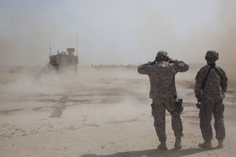 Soldiers cover their ears during an artillery qualification at Besamaya Range in Forward Operating Base Hammer, Iraq.