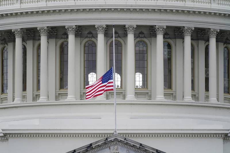 An American flag flies at half-staff in remembrance of U.S. Capitol Police Officer Brian Sicknick above the Capitol Building in Washington, Friday, Jan. 8, 2021.