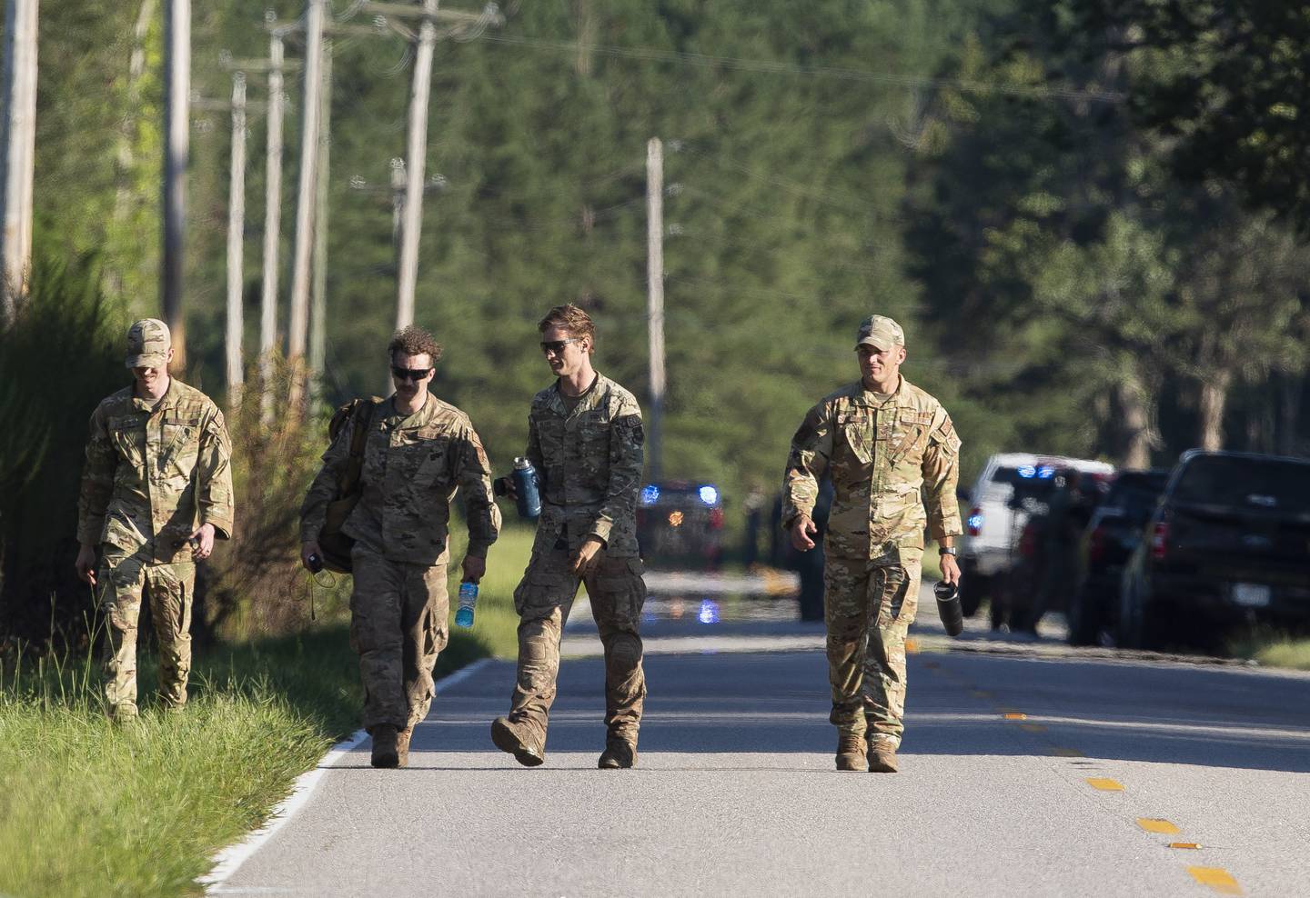 Airmen from Joint Base Charleston walk down Old Georgetown Road when setting up a base during the recovery process for an F-35 that crash landed in a field nearby in Williamsburg County, S.C., on Monday, Sept. 18, 2023.