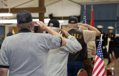 Military veterans salute the American flag at the Barstow Senior Citizens Center in Barstow, California, on Nov. 4, 2013.