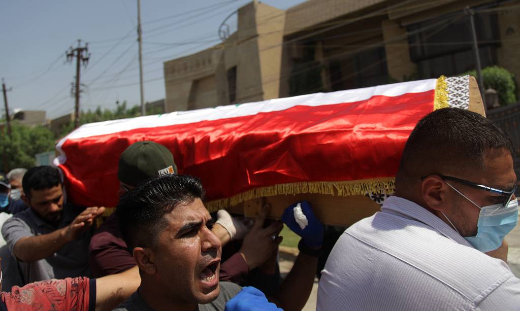 Mourners carry the flag-draped coffin of Hisham al-Hashimi during his funeral, in the Zeyouneh area of Baghdad on July, 7, 2020.