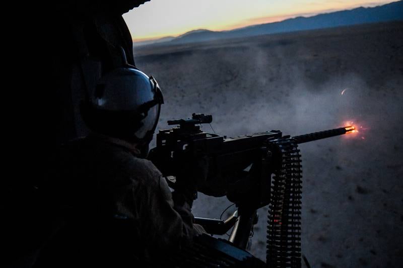 Naval Aircrewman (Helicopter) 3rd Class Copper McCambridge fires a .50-caliber machine gun during an initial aerial gunnery training qualification at Naval Air Facility El Centro, Calif, on Oct. 10, 2020.