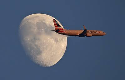 An American Airlines jetliner flies past the moon on Sept. 1, 2017, in Arlington, Texas.