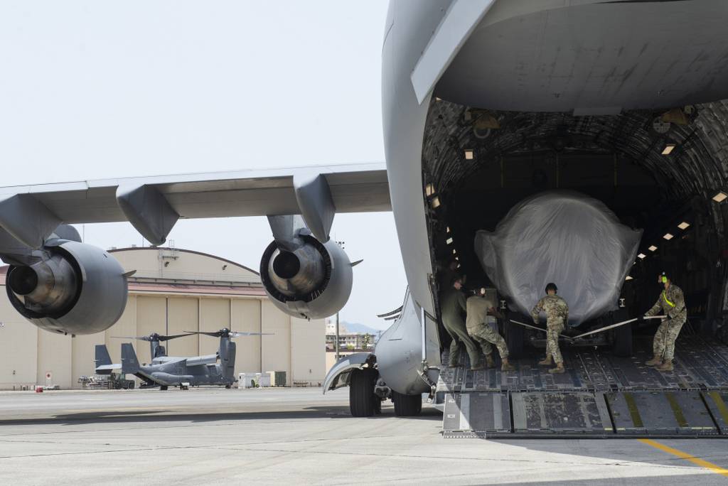 Airmen assigned to the 730th Air Mobility Squadron load a C-17 engine onto a C-17 Globemaster III May, 4, 2021, at Yokota Air Base, Japan. (Tech. Sgt. Christopher Hubenthal/Air Force)