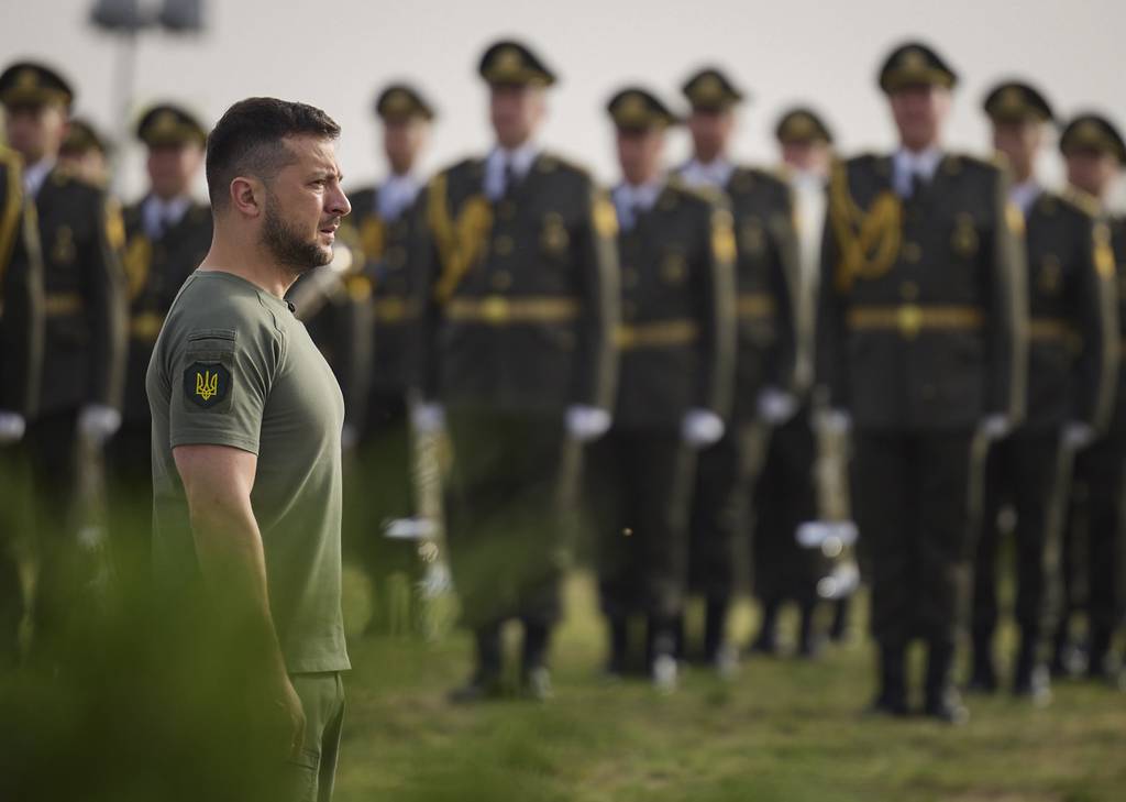 Ukrainian President Volodymyr Zelenskyy stands in front of lined up soldiers as he arrives for State Flag Day celebrations in Kyiv, Ukraine, Tuesday, Aug. 23, 2022.