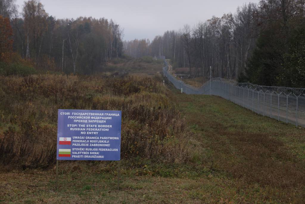 A warning sign stands on the Russian side next to a Lithuanian border fence near the precise point where the borders of Poland, Lithuania and the Russian semi-exclave of Kaliningrad meet as seen on Oct. 28, 2022, near Zerdziny, Poland.
