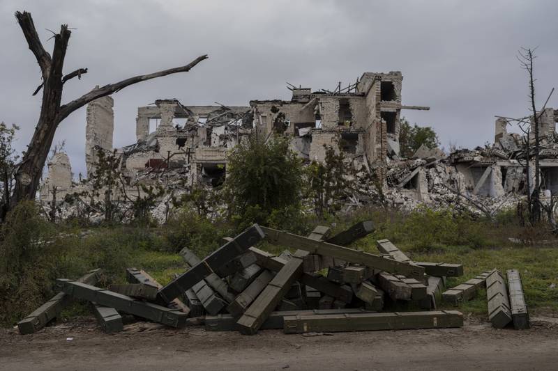 Ammunition boxes lay outside a destroyed school on the outskirts of a recently liberated village outskirts of Kherson, in southern Ukraine, Wednesday, Nov. 16, 2022.