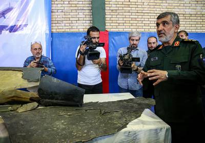 Gen. Amir Ali Hajizadeh, right, Iran's head of the Revolutionary Guard's aerospace division, speaks to media next to debris from a downed U.S. drone reportedly recovered within Iran's territorial waters and put on display by the Revolutionary Guard in the capital Tehran