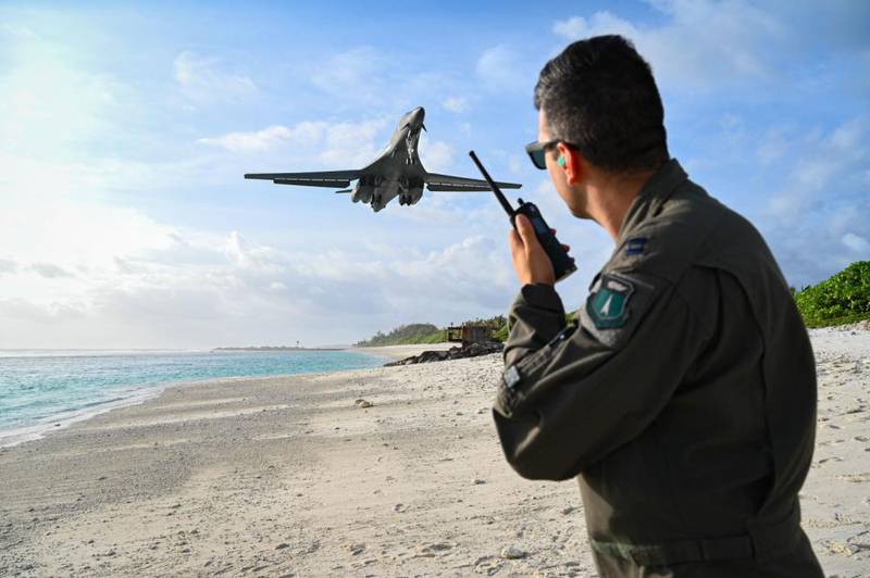 Capt. Orr “Recoil” Genish, 37th Bomb Squadron weapons systems officer, uses a land mobile radio as he watches a B-1B Lancer land in support of a Bomber Task Force mission at Naval Support Facility Diego Garcia, Oct. 17, 2021. (Staff Sgt. Hannah Malone/Air Force)