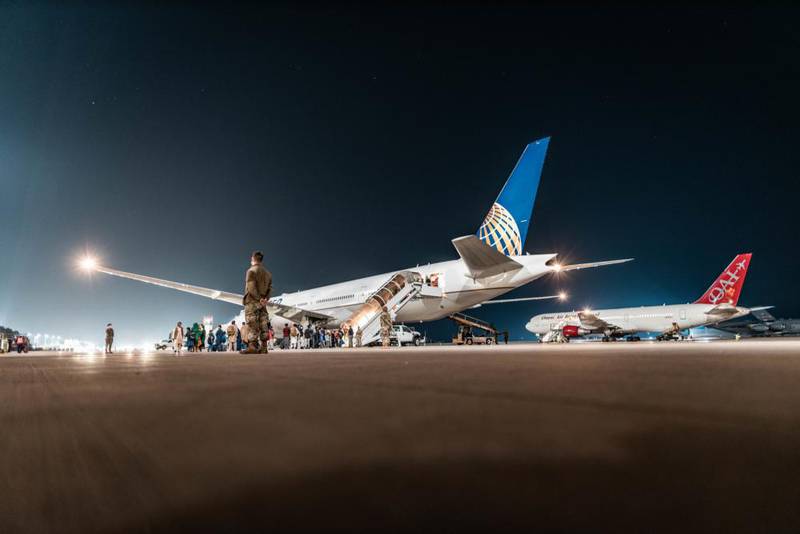 Evacuees from Afghanistan board a commercial aircraft at Ramstein Air Base, Germany, Sept. 7, 2021. Civil Reserve Air Fleet aircraft are being used for the onward movement of evacuees from temporary safe havens and interim staging bases. (Tech. Sgt. Aaron Luetzen/Air Force)