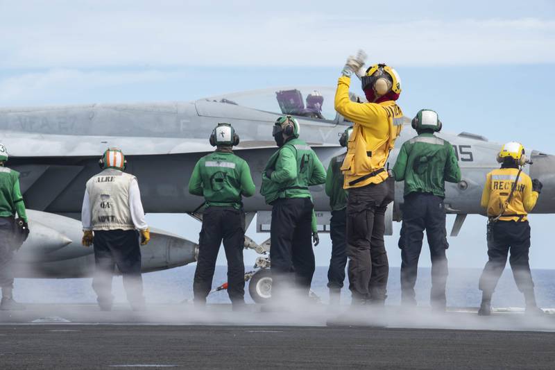 Sailors prepare to launch an F/A-18E Super Hornet on the flight deck of the aircraft carrier USS Ronald Reagan (CVN 76) on June 18, 2020, during flight operations in the Philippine Sea.