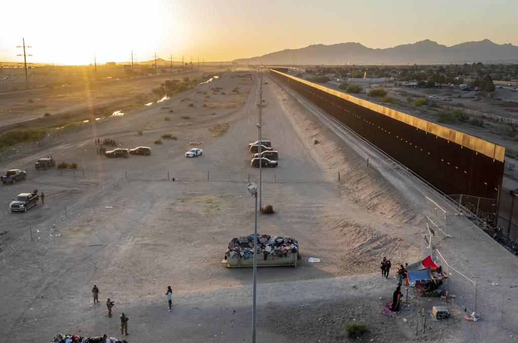 A small group of migrants, bottom right, are pictured while camping outside a gate in the border fence in El Paso, Texas, Friday, May 12, 2023.
