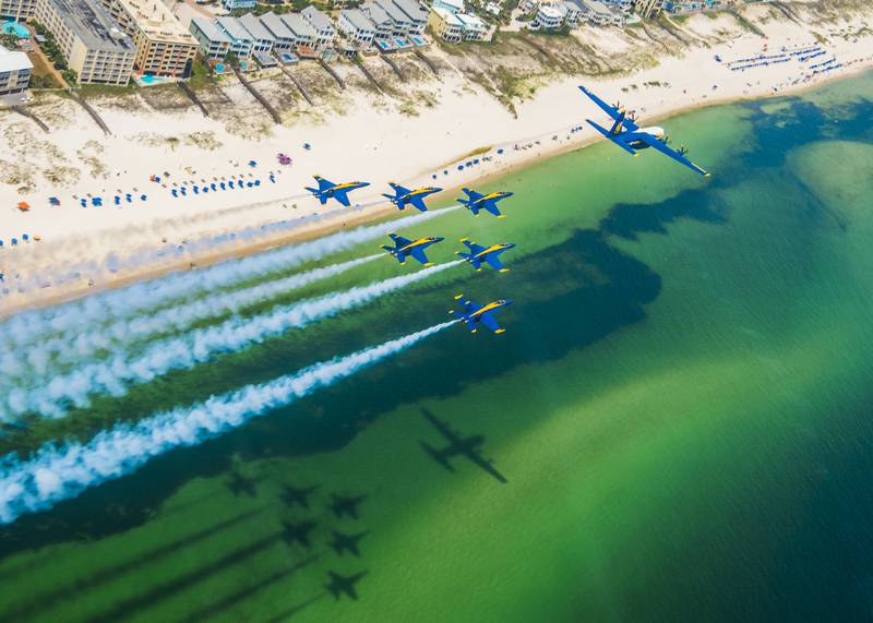 The U.S. Navy Flight Demonstration Squadron, the Blue Angels, C-130 pilots and crew arrive at Naval Air Station Pensacola with the team’s new C-130J Super Hercules, alongside the Blue Angel delta formation on Aug. 17, 2020.