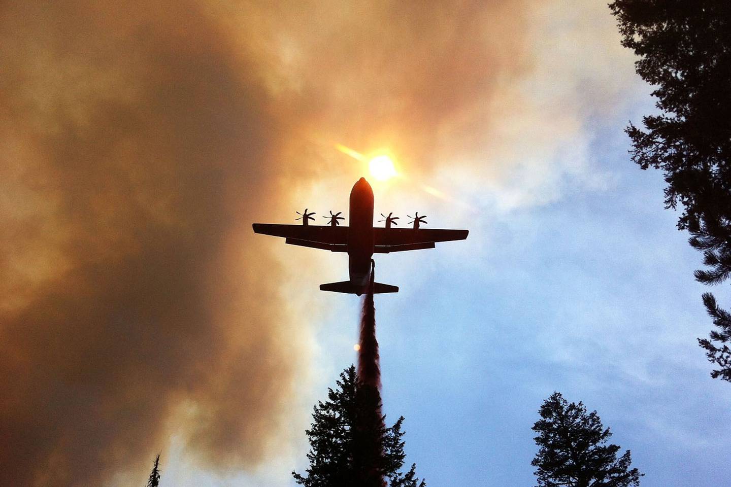 WILDFIRE ASSISTANCE -- A California Air National Guard C130-J Hercules, equipped with Modular Airborne Firefighting System, drops retardant on a wildfire near Twin Falls, Idaho, Aug. 8, 2012. (DOD photo)