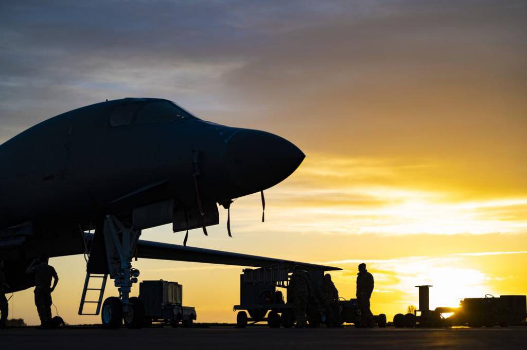 B-1B Lancer aircraft maintenance and munitions specialists assigned to the 9th Expeditionary Bomb Squadron stand next to the aircraft after finishing loading munitions at RAF Fairford, United Kingdom, Oct. 29, 2021. Four B-1s, supporting equipment and approximately 200 airmen are currently deployed with the 9th EBS while supporting U.S. European Command. (Senior Airman Colin Hollowell/Air Force)