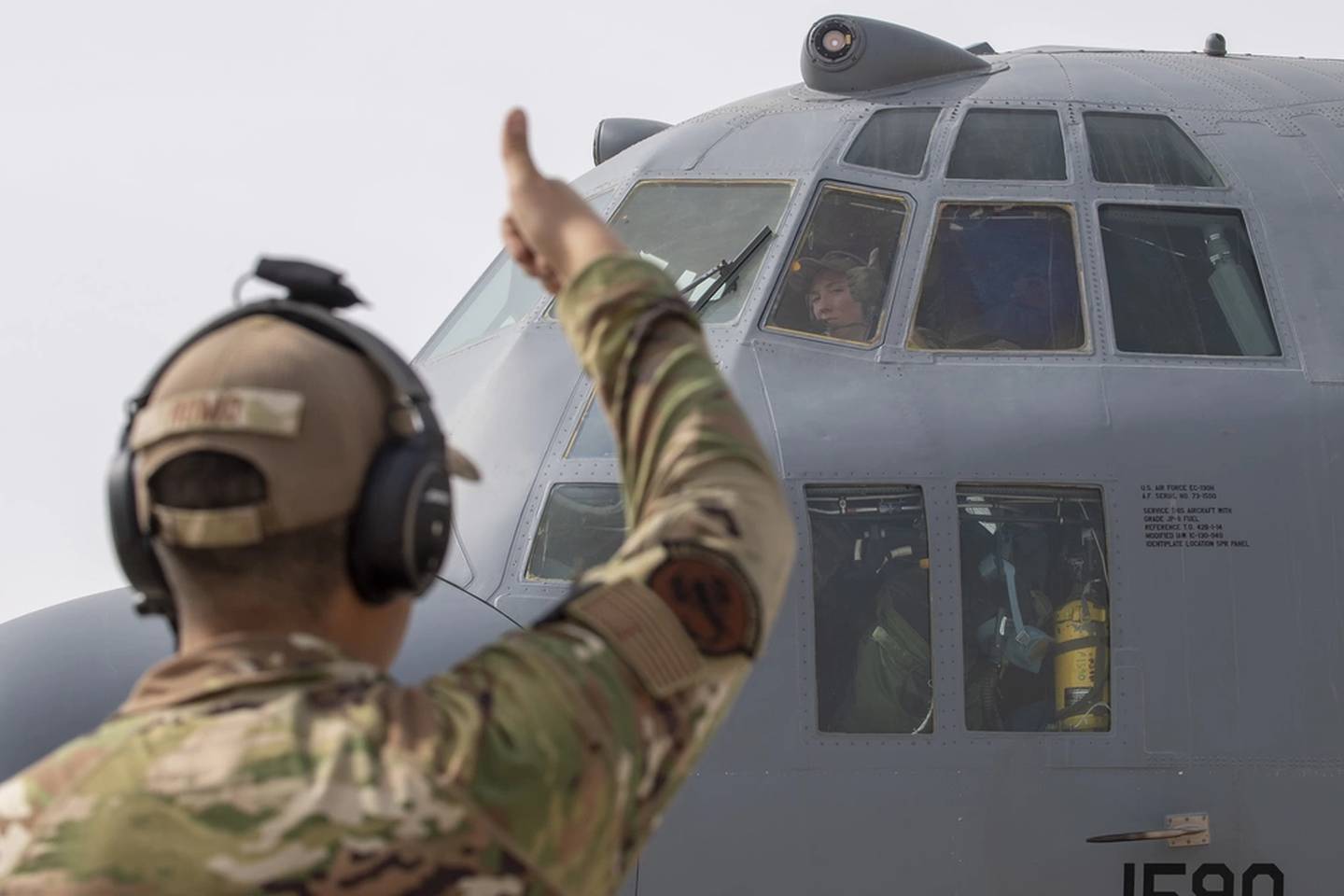 U.S. Air Force Capt. Taylor Drolshagen, 41st Expeditionary Electronic Combat Squadron pilot, signals to Airman 1st Class Logan Romo, 41st EECS airborne maintenance technician, as she starts the engine of an EC-130H Compass Call aircraft in preparation for a large force employment exercise at Al Dhafra Air Base, United Arab Emirates, July 13, 2021. (Master Sgt. Wolfram M. Stumpf/Air Force)