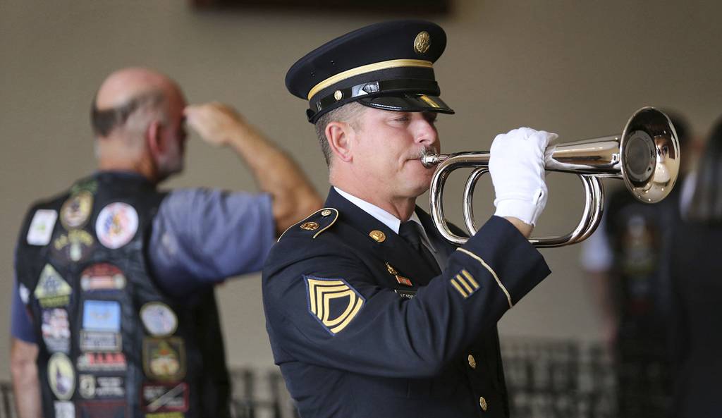 A member of the U.S. Army Honor Guard plays "Taps" in memory of Stephen Jerald Spicer, a homeless U.S. Army veteran, during a full military honors service at Woodlawn Memorial Park in Gotha, Fla., July 18, 2019.
