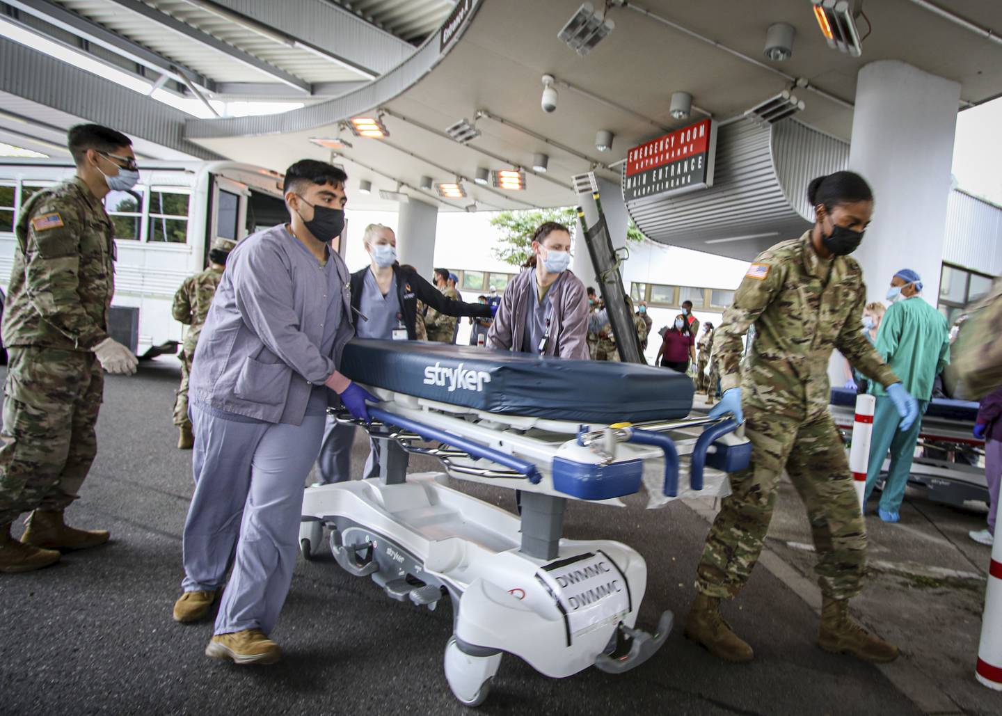 In this image provided by the U.S. Army, soldiers, airmen and civilian staff at Landstuhl Regional Medical Center, Germany, receive injured on Friday, Aug. 27, 2021, who were medically evacuated from Kabul, Afghanistan, after the bombing outside of Hamid Karzai International Airport in Kabul, Afghanistan, on Aug. 26. (Marcy Sanchez/U.S. Army via AP)