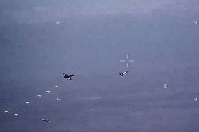 In this image from video released by the U.S. Air Force, Russian military SU-34 and SU-35 aircraft release flares in the flight path of a U.S. Air Force MQ-9 Reaper drone, lower left, on Thursday, July 6, 2023, over Syria.
