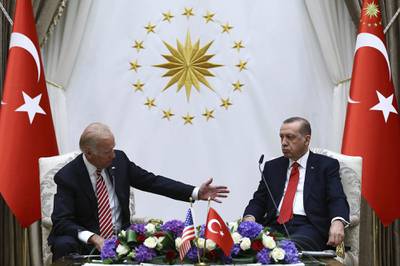 Then-Vice President Joe Biden, left, speaks with Turkish President Recep Tayyip Erdogan as they sit in front of flags for Turkey.