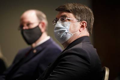 Secretary of Veterans Affairs Richard Wilkie, right, next to Under Secretary of Defense for Personnel and Readiness Matthew Donovan, left, wear protective masks against COVID-19, listen during a program to raise awareness on the risks of veterans suicide on July 7, 2020, at the National Press Club in Washington.