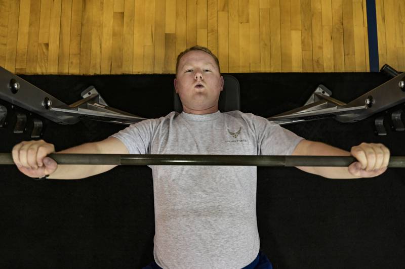 Senior Airman James Fritz, 911th Airlift Wing public affairs specialist, performs a barbell bench press in the gym at the Pittsburgh International Airport Air Reserve Station, Pennsylvania, Jan. 25, 2021. Although all Air Force fitness tests are suspended until July, all Airmen are expected to maintain their personal physical readiness. (Joshua J. Seybert/Air Force)