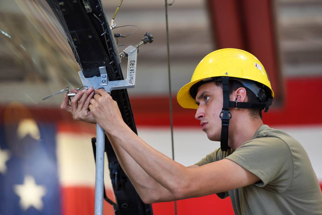 Senior Airman Andres Espinoza, 31st Maintenance Squadron egress journeyman, pins a canopy support strut on an F-16 Fighting Falcon at Aviano Air Base, Italy, Aug. 11, 2022. Egress specialists perform inspections and maintenance on F-16 canopies and egress systems to ensure the components function properly in flight and during emergencies. (Senior Airman Brooke Moeder/Air Force)