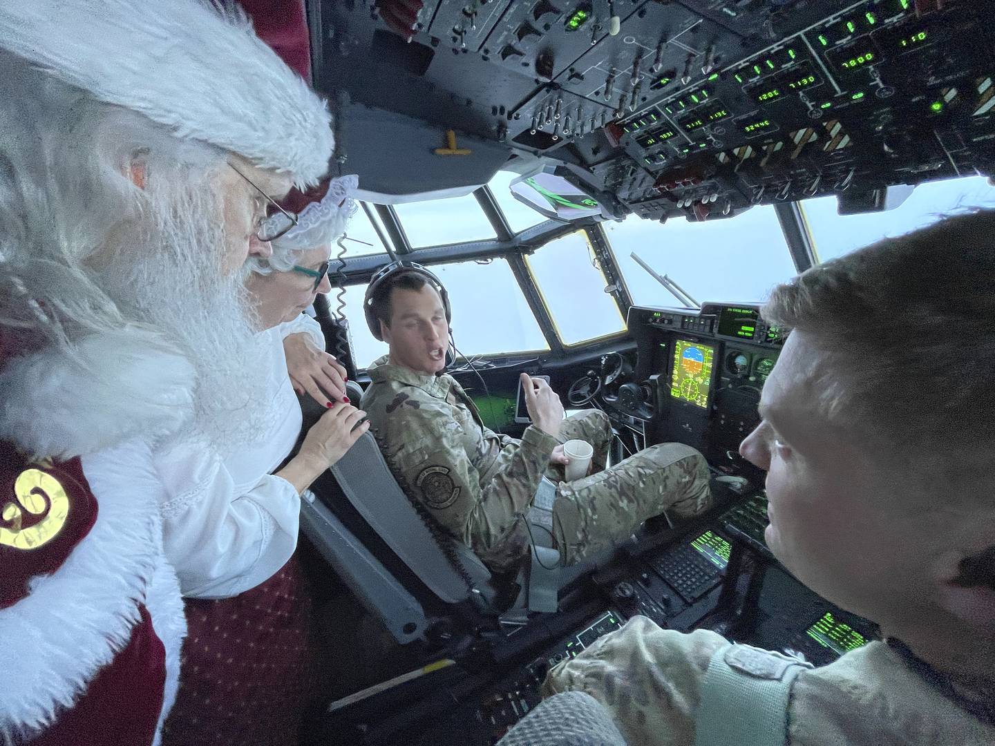 Santa and Mrs. Claus chat with the flight crew of an Alaska National Guard cargo plane while en route to Nuiqsut, Alaska, on Tuesday, Nov. 29, 2022.